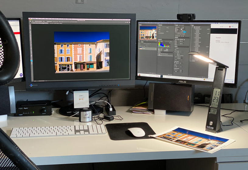 Mon bureau et son mur gris derrière les écrans de retouches photo